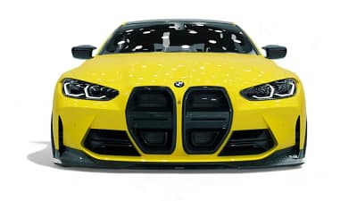 Front view of yellow BMW G82 M4 with full carbon kit